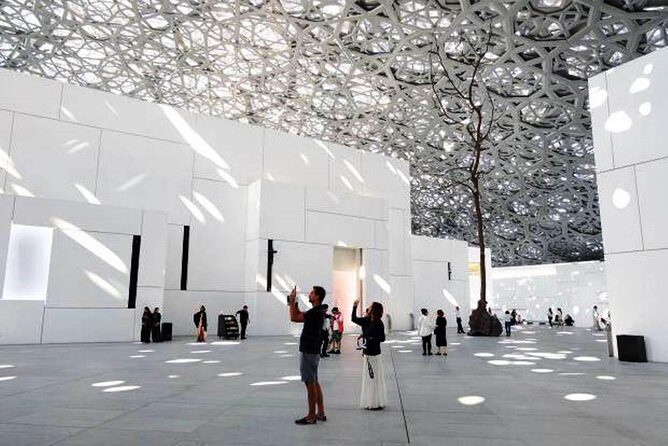 Abu Dhabi Marvelous highlights with Louvre,Grand Mosque & 5<em>lunch – Sheikh Zayed Grand Mosque: the inside visit you should plan around’ /><br />
The mosque visit is the heavyweight moment of the day. You get about three hours at the Sheikh Zayed Grand Mosque Center area, including the inside visit.</p>
<p><p>What makes this stop so special is the detail level. The mosque’s interior is known for Swarovski chandeliers, hand-woven carpets, and breathtaking marble work. When you have a guide, it’s easier to slow down and notice those elements, instead of rushing through the biggest photo angles.</p>
</p>
<p><p>The guide also helps with the practical realities of visiting. That includes knowing where to stand, what to look at first, and how to manage the flow of entry and movement inside the mosque.</p>
</p>
<h3 id="dress-code-dont-wing-it">Dress code: don’t wing it</h3>
<p>This is not the place for last-minute improvising. The dress code is strict, and failure to follow it can mean entry is restricted.</p>
<p><p>Women should wear conservative, loose-fitting, non-transparent clothing with long sleeves (up to the wrist) and long skirts (up to the ankle) or trousers. A headscarf is required before entering the mosque.</p>
</p>
<p><p>Men should avoid revealing flesh above the knees, and shoulders must be covered. Tattoos must be covered.</p>
</p>
<p><p>You also remove footwear before entering the mosque.</p>
</p>
<p><p>If you’re missing an abaya, renting one as part of a tour is not feasible. In an emergency situation, you can purchase an abaya from your tour guide for about USD 10, depending on availability. That’s a useful safety net, but it’s still best to come prepared.</p>
</p>
<h3 id="heat-tip-for-summer">Heat tip for summer</h3>
<p>If you’re visiting June through September, plan for peak daytime temperatures that can reach 42–45°C, with humidity that can exceed 90 percent. The tour notes you should take adequate precaution.</p>
<p><p>The good news is that the day includes air-conditioned vehicle transport and a hotel lunch, so you’re not out there all day in open sun. Still, bring your best “survive the heat” kit: the guidance specifically advises good quality sunglasses and hats in direct sunlight.</p>
</p>
<h2 id="timing-and-transport-what-a-5-hour-day-feels-like">Timing and transport: what a 5-hour day feels like</h2>
<p><img width="670" height="446" decoding="async" src=