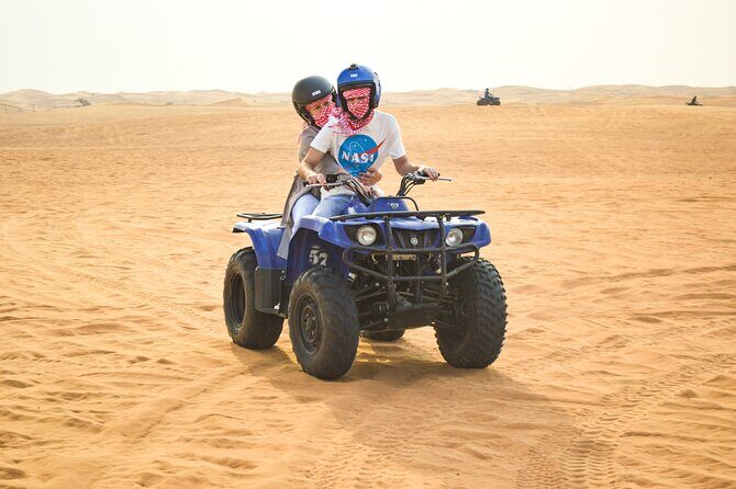 Evening Desert Safari with Quad Bike, BBQ Dinner and Camel Ride - Camp at night: majlis seating, henna, falcons, and shisha area